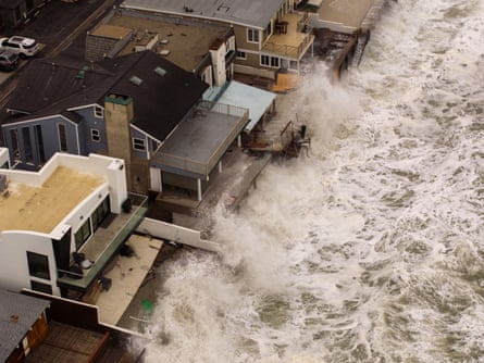 Aerial view of large storm waves crashing into beachfront homes in Dana Point, California