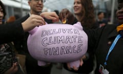 Participants contribute coins into a piggy bank during the World Climate Change Conference 2015