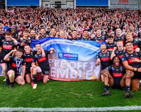 Wigan Warriors line up with a banner saying 'We're on our way to Wembley' after their Challenge Cup semi-final victory.