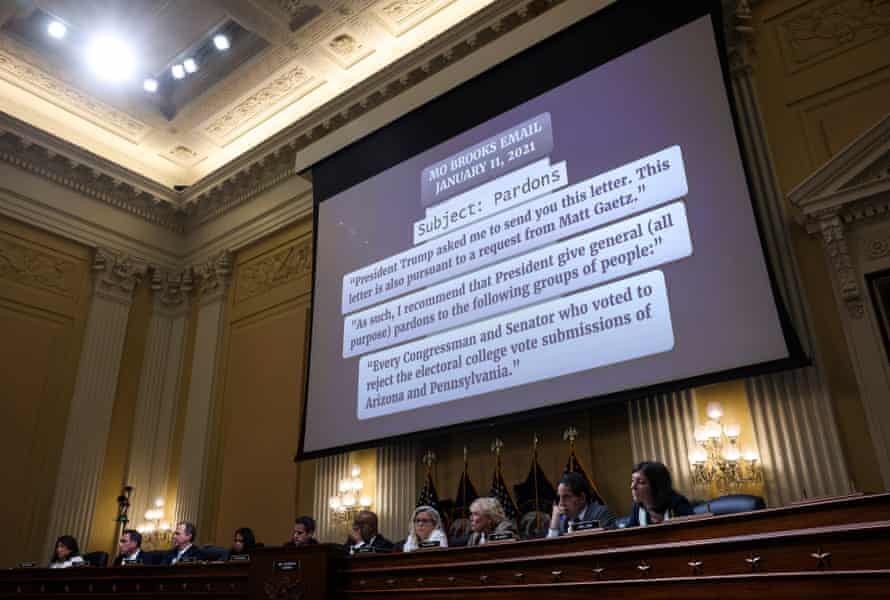 A screen above the January 6 committee displays snippets from an email from Mo Brooks. The middle snippet reads, 'As such I recommend that President give general (all purpose) pardons to the following groups of people:'