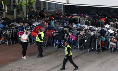 Airport workers stand next to lines of passenger luggage arranged outside Terminal 2 at Heathrow Airport in London, Britain, on 19 June.