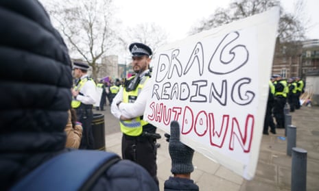 A protester outside the Tate Britain holds a sign reading ‘Drag reading shutdown’ in front of police