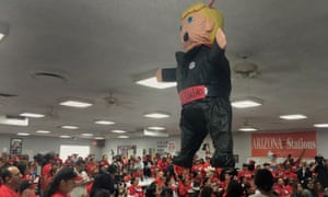 Members of the Culinary Workers Union Local 226, cheer during a rally under a Donald Trump pinata in Las Vegas.