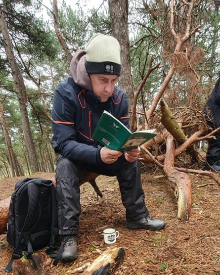Peter outdoors in woodland reading a book