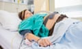 Pregnant woman lying on a hospital bed with IV and epidural