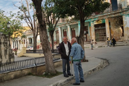Two men stand next to each other in a square in Havana