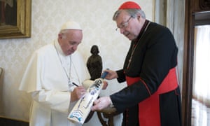 Pope Francis signs a cricket bat he received from Cardinal George Pell, at the Vatican, Oct. 29, 2015. He said Pell had a right to the benefit of the doubt like all those accused.