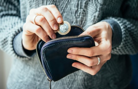 Mains tenant une pièce de monnaie et une petite pochette d'argent