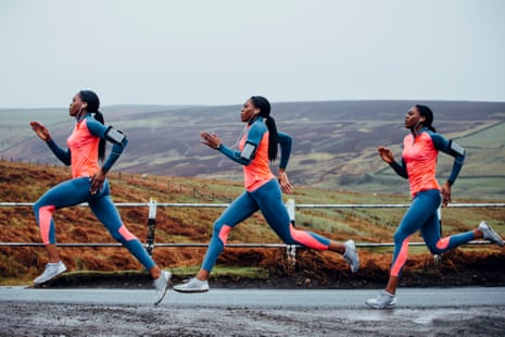 Female out in the wilderness running fast along a rural road while listening to music on headphones