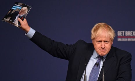Boris Johnson holds up a copy of the Tory manifesto.