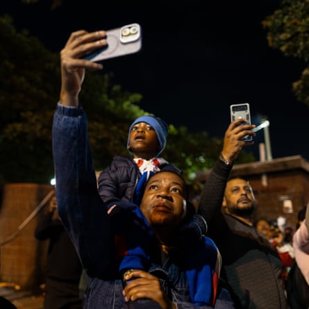 Supporters hold up mobile phones