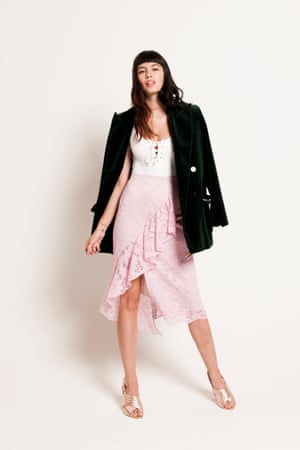 pink skirt with ruffle along the front, white body with lace-up front, green velvet jacket, rose gold block heeled shoes with padded straps