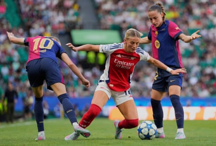 Arsenal's Chloe Kelly, centre, duels for the ball with Barcelona's Caroline Graham Hansen, and Ona Batlle