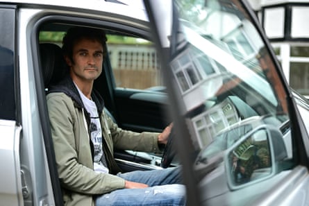 Man sits in drivers seat of car.