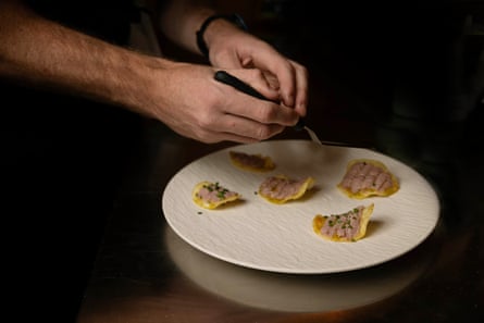 Synthetic parfait on potato chips with chopped chives and lemon myrtle oil.
