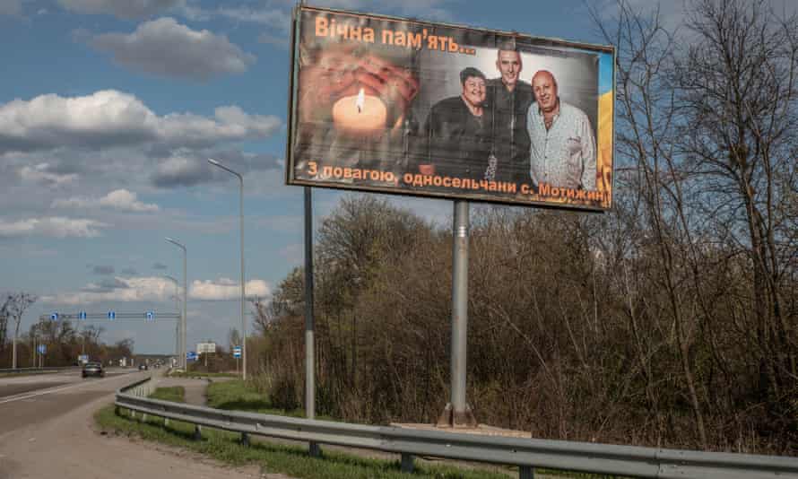 A large billboard of Olga Petrivna with her husband and son marks the entrance to Motyzhyn village