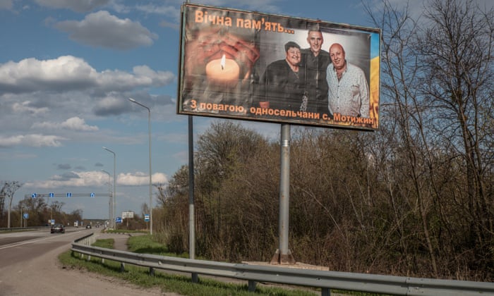 A billboard displaying a photo of Olga Petrivna, the head of Motyzhyn’s village, with her husband and son.
