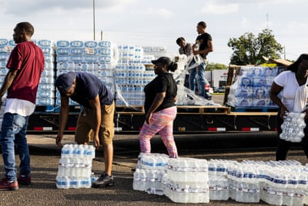 Cases of bottled water are handed out in Jackson on 31 August.