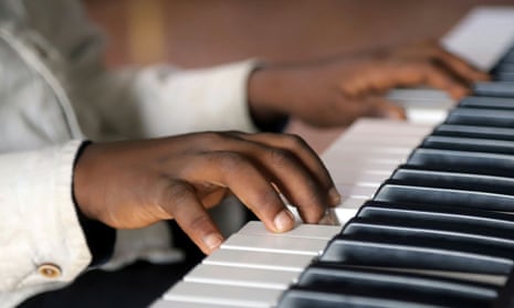 A child's hands playing an electronic keyboard