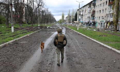 A Ukrainian policeman walks on a street among heavily damaged buildings in Avdiivka, Donetsk region.