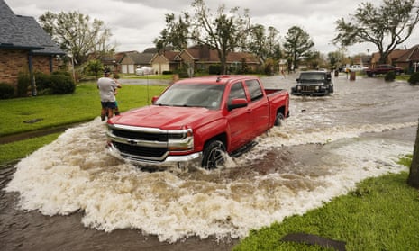 Vehicles pass through a flooded street after Hurricane Ida moved through in LaPlace, Louisiana, on Monday.