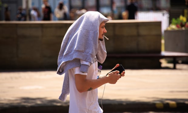A man in Manchester covers his head during this week’s heatwave.