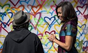Washington, US To celebrate International Women’s Day, first lady Michelle Obama talks to artist Mr. Brainwash during a live painting of a Let Girls Learn mural at Union Market