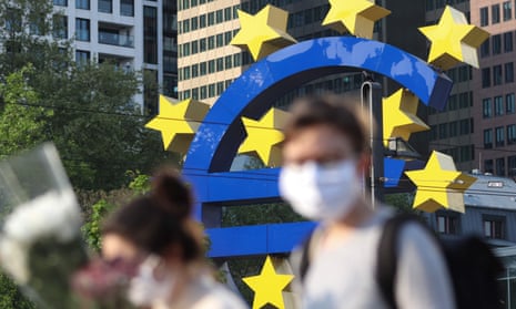 People with face masks pass the big euro sign outside the European Central Bank HQ in Frankfurt.
