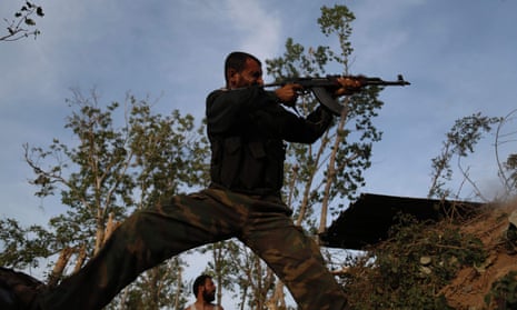 A Syrian rebel fighter aims his gun