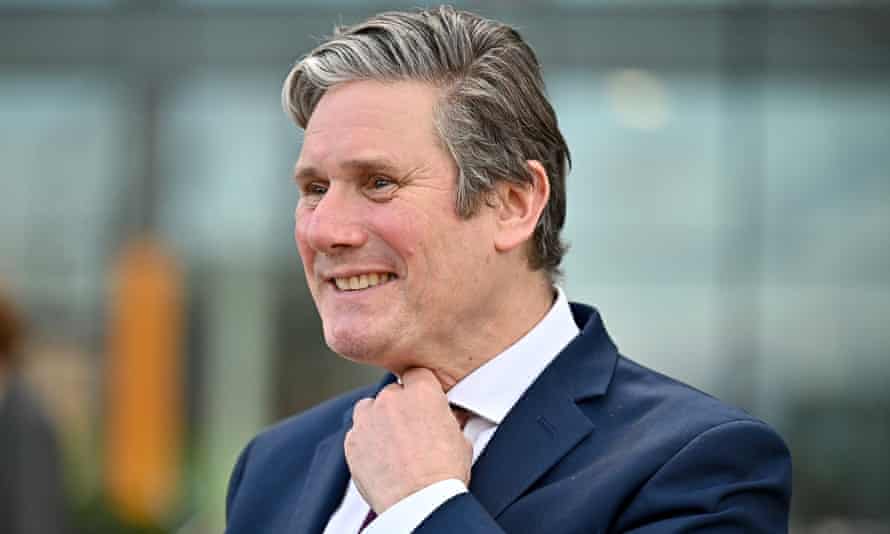 Keir Starmer adjusts his tie