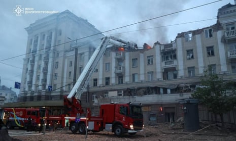 Firefighters try to extinguish a fire that broke out in a five-story building that was partially destroyed after a Russian missile strike.