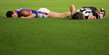 Daniel Giansiracusa of the Bulldogs and Justin Koschitzke lying on the ground