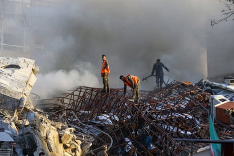 Emergency personnel extinguish a fire at the site of strikes which hit a building next to the Iranian embassy in Syria's capital Damascus.