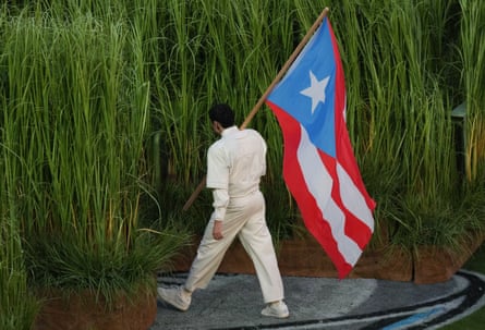 Bad Bunny carries a Puerto Rican flag.