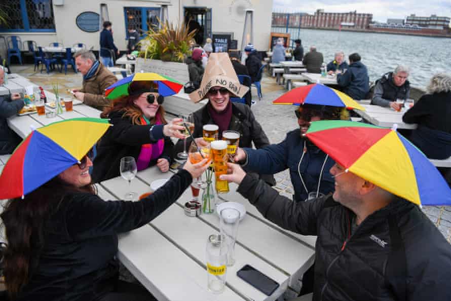 Members of the public enjoy a drink outside at The Still &amp; West pub at Spice Island in Portsmouth, England.