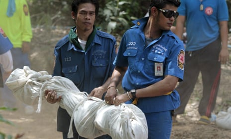 Rescue workers carry a body bag with remains retrieved from a mass grave in Thailand’s southern Songkhla province.