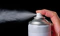 Close-up of a spray can with someone pressing down the cap with gas coming out