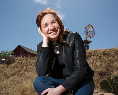Climate scientist Katharine Hayhoe sitting on a rock outside