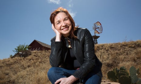 Climate scientist Katharine Hayhoe sitting on a rock outside