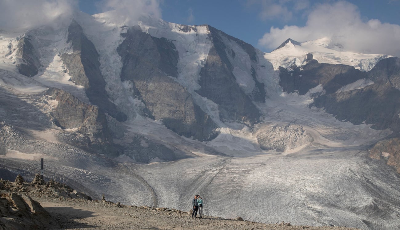 A couple takes a selfie in front of the Pers Glacier