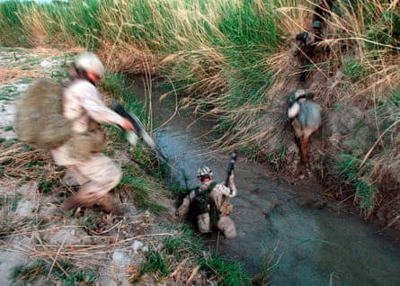 Canadian and Afghan soldiers cross a canal