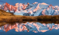 Alpen glow and the Mont Blanc Massif and its reflection in a mountain lake not far from the summit of Aiguillette du Brevent, Chamonix, France.