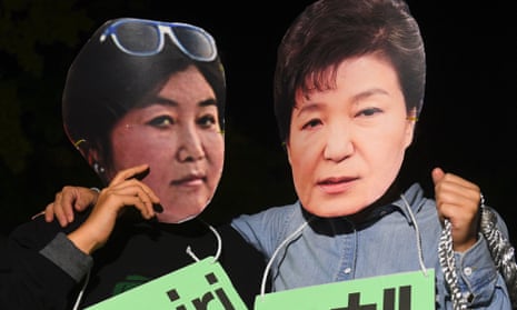 Protesters in Seoul wear masks depicting South Korean president Park Geun-hye, right, and her confidante Choi Soon-sil