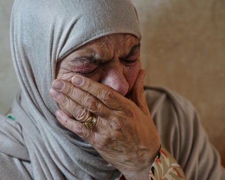Feryal Abu Haikal, the grandmother of seven month old Palestinian boy, looking very distraught holding her hand up to her face.