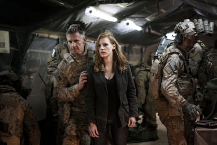 A soldier holds a woman dressed in black in a bunker