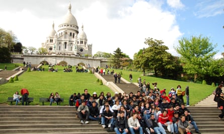 A school group of teenagers pose for a snapshot in front of the Sacre-Coeur in Paris.