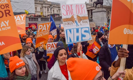 A protester holds a placard which states 'save our broken and broke NHS' during the demonstration in Trafalgar Square on Wednesday.
