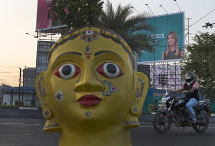 A motorist rides past a billboard poster of Ivanka Trump as a statue is erected at the entrance of the summit in Hyderabad.