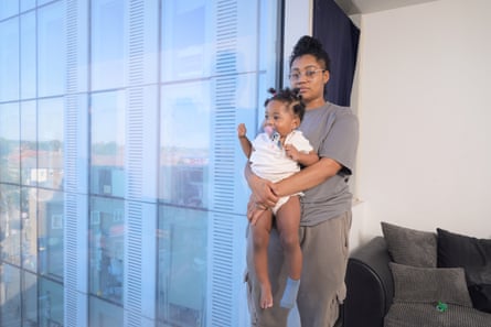 Sabrina Walters holding Cal-Lisa while stood next to a large window in the flat