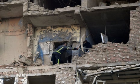 A rescuer evacuates a woman from a multi-storey residential building partially destroyed after a night drone attack in Kyiv.